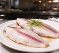 Fresh sea bream fillets with pink lateral line on a white plate