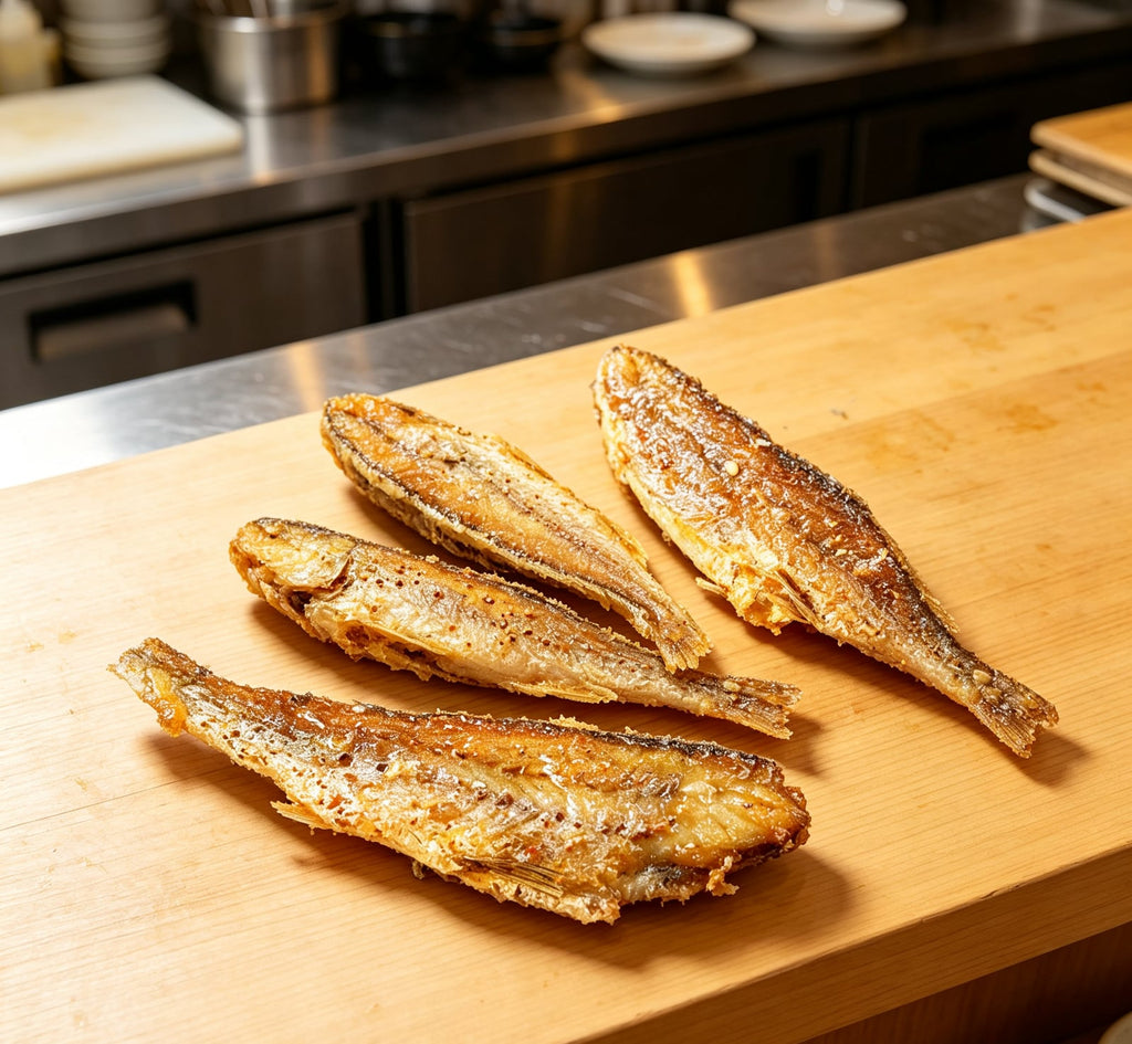 Golden pan-fried yellow croaker fish on a wooden board